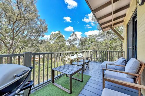 a deck with chairs and a table and a grill at Villa 2br Dolcetto Villa located within Cypress Lakes Resort in Pokolbin