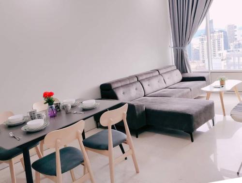 a living room with a couch and a table and chairs at Sky Suites KLCC by KD Luxury Suites in Kuala Lumpur