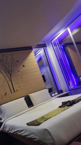 a bedroom with a bed and a window with purple lights at Theringkhokmao in Ban Tha Sae