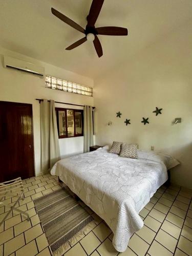 a bedroom with a bed with a ceiling fan at Casa Mara Beachfront -Heated Pool in Sayulita