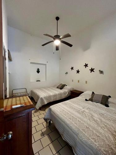 a bedroom with two beds and a ceiling fan at Casa Mara Beachfront -Heated Pool in Sayulita