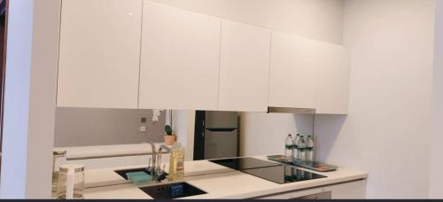 a kitchen with white cabinets and a refrigerator at Sky Suites KLCC by KD Luxury Suites in Kuala Lumpur