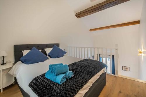 une chambre avec un lit avec des serviettes bleues dessus dans l'établissement Le Lithographe Duplex, à Narbonne