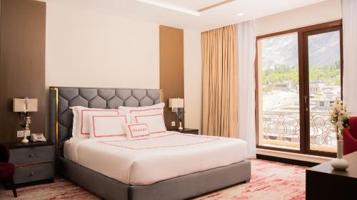 a bedroom with a bed and a large window at Ramada Resort by Wyndham Gilgit in Gilgit