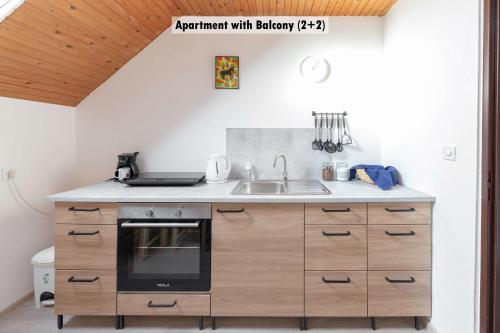 a kitchen with a sink and a stove at Apartments Farm House Uric in Jesenice