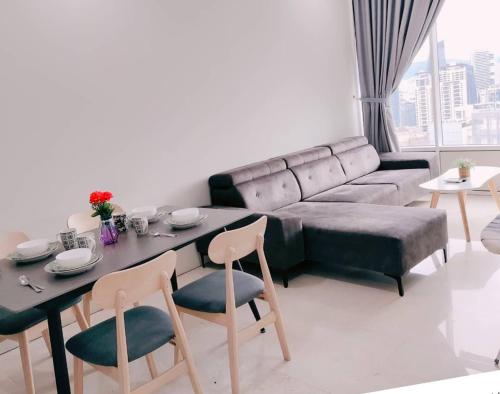 a living room with a couch and a table and chairs at Sky Suites KLCC by KD Luxury Suites in Kuala Lumpur