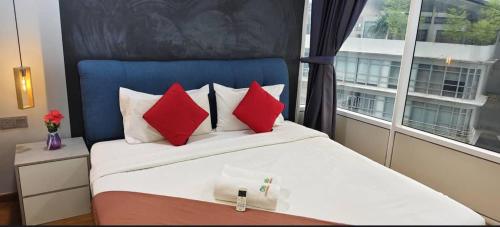 a bedroom with a bed with red pillows and a window at Sky Suites KLCC by KD Luxury Suites in Kuala Lumpur
