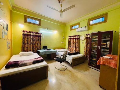 SibsāgarParag Abode - A Luxury Homestay的有两张床和一张书桌的房间