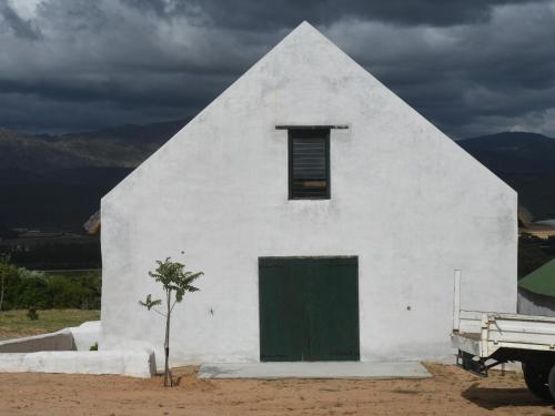 a white building with a green door and a truck at The Old Village in Citrusdal
