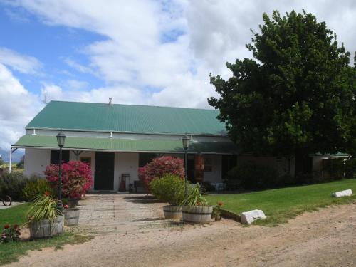 a building with a green roof and some plants at The Old Village in Citrusdal