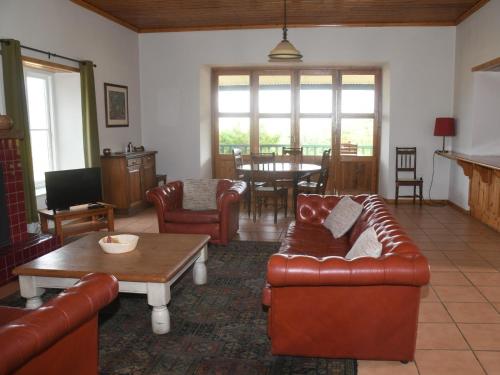 a living room with leather furniture and a table at The Old Village in Citrusdal