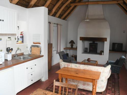 a kitchen and living room with a table and chairs at The Old Village in Citrusdal