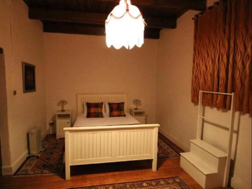 a bedroom with a bed and a chandelier at The Old Village in Citrusdal