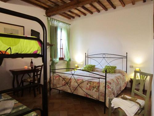 1 dormitorio con 1 cama y 1 mesa en B&B Le Logge Di Sopra, en Asciano