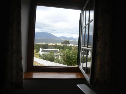 an open window with a view of a house at The Old Village in Citrusdal