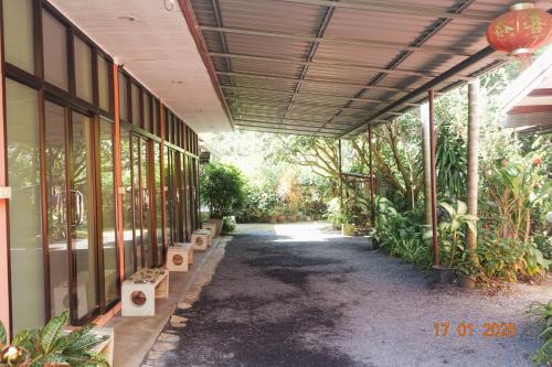 a hallway of a building with trees and plants at Subsavet Village in Baan Tai