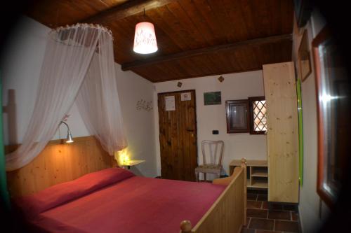 a bedroom with a bed with a red comforter at B&B Le Stagioni in Castel del Monte