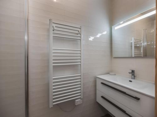 une salle de bain blanche avec un lavabo et un miroir dans l'établissement BO Immobilier - Apt PDS A306 - Châtel, à Châtel
