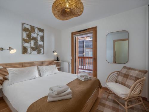 une chambre avec un lit, une chaise et un miroir dans l'établissement BO Immobilier - Apt PDS A306 - Châtel, à Châtel