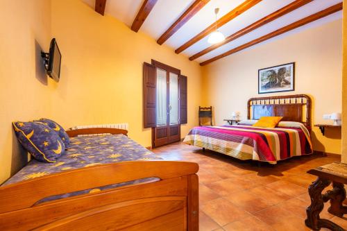 una camera da letto con due letti in una stanza di Les Oliveres Mil·lenaries I a La Jana