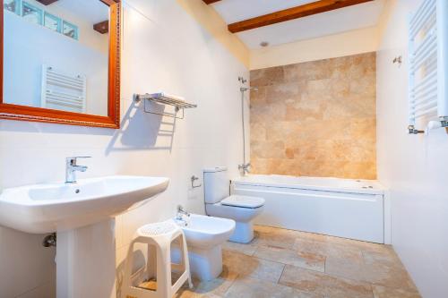 un bagno con lavandino, WC e specchio di Les Oliveres Mil·lenaries I a La Jana