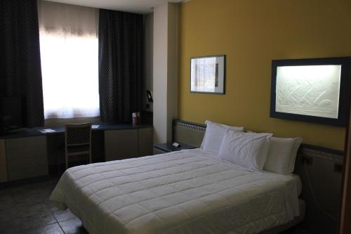 a bedroom with a large white bed with a window at President Hotel Palermo in Palermo