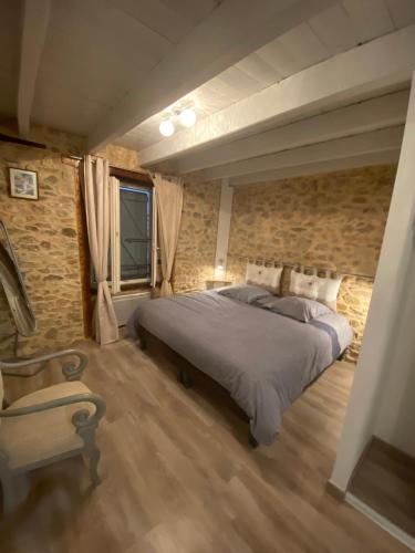 a bedroom with a bed and a stone wall at Gîte D Arsonval in La Porcherie