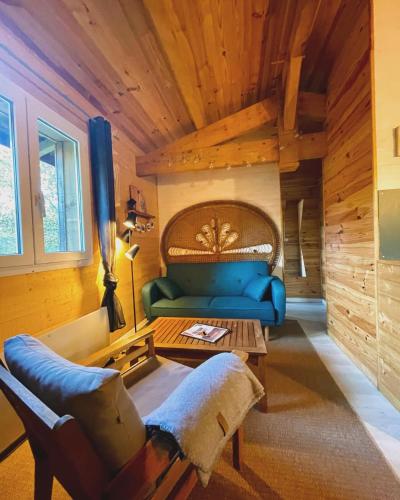 un salon avec un canapé bleu et une table dans l'établissement Gîte familial en pleine nature- Domaine Temali, à Labouheyre