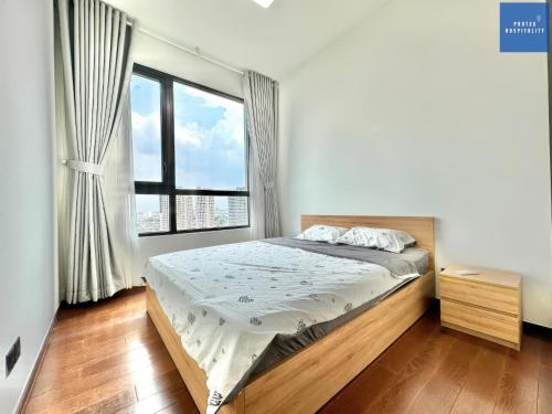 a bedroom with a bed and a large window at D'Edge Thao Dien - SkyPool Paradise in Ho Chi Minh City