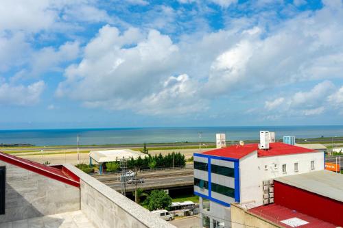 a building with a red roof next to the ocean at Grand Bektas Suite in Trabzon