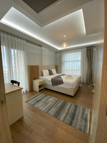 a bedroom with a white bed and a rug at Grand Bektas Suite in Trabzon