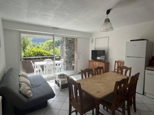 Il comprend un salon avec une table et une cuisine avec une salle à manger. dans l'établissement Grand chalet équipé et calme avec parking à Cauterets - FR-1-812-124, à Cauterets