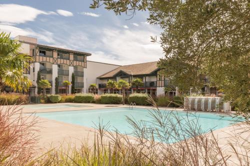 une piscine devant un immeuble dans l'établissement Village Pierre & Vacances Moliets, à Moliets-et-Maa