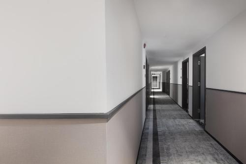 a hallway with white walls and a long corridor at Mcsrh Hotel-Guiyang Xiaoshizi in Guiyang