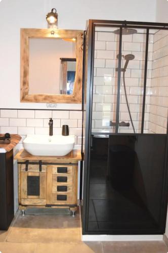 une salle de bain avec un lavabo et une douche dans l'établissement Au Refuge Des Loups, à Zutkerque