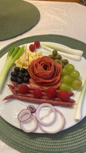 a plate with fruit and vegetables on a table at Gasthof Frasswirt in Frass