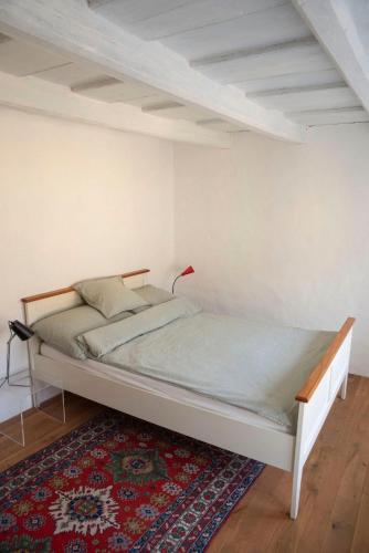 a bed in a room with a red lamp on a rug at dasFritsch-Historisches Weinbauernhaus im Grünen in Klein-Reinprechtsdorf