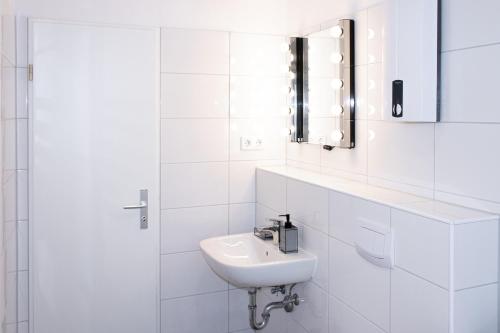 a white bathroom with a sink and a mirror at Gemütliche 2-Zimmer Wohnung, zentrale Lage, Smart TV in Bahnhof Essen Süd