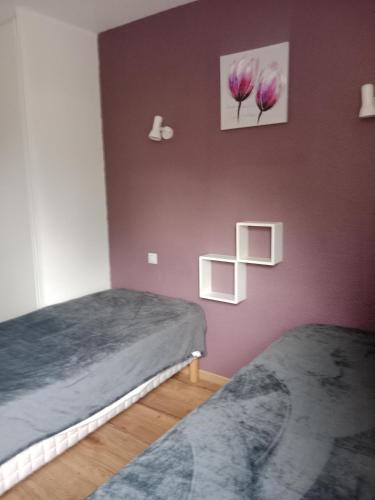 deux lits dans une chambre aux murs violets dans l'établissement DIGNE LES BAINS, à Digne-Les-Bains