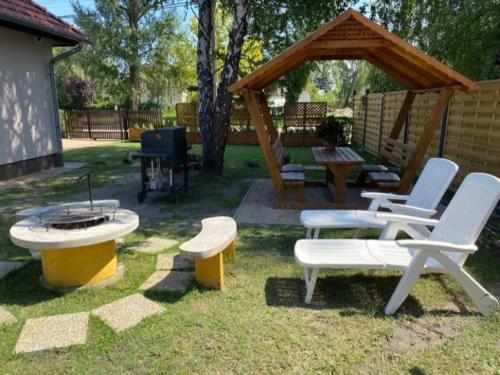 a group of chairs and a fire pit in a yard at Írisz Apartman teljes ház in Balatonmáriafürdő