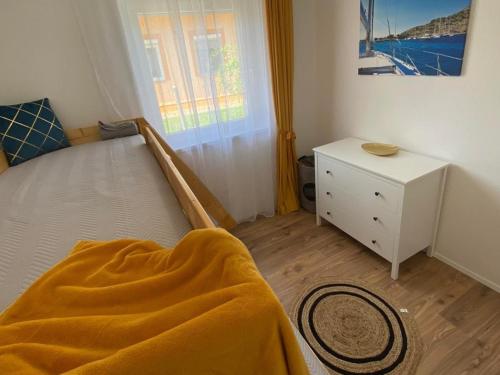 a bedroom with a bed with a yellow blanket at Írisz Apartman teljes ház in Balatonmáriafürdő