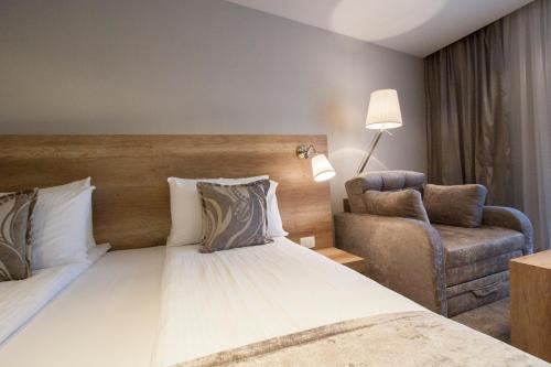 a hotel room with a bed and a chair at Villa Dea in Ohrid