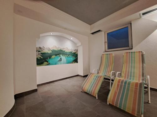 two chairs in a room with a painting on the wall at Hotel Tia Apart in Kaunertal