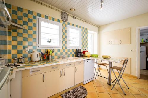 une cuisine avec un évier et une table à l'intérieur dans l'établissement La maison du Bétey pour 4 à 5 personnes plage à 50 m, à Andernos-les-Bains