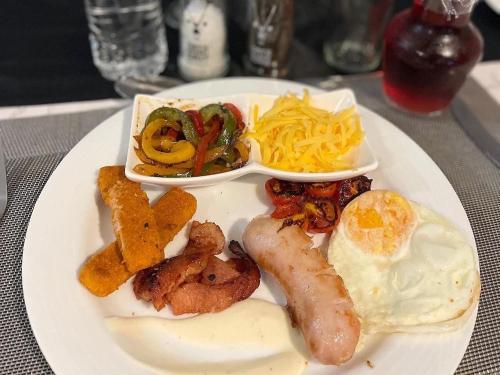 a plate of breakfast food with eggs sausage and vegetables at Catwalk Lodge in Pretoria