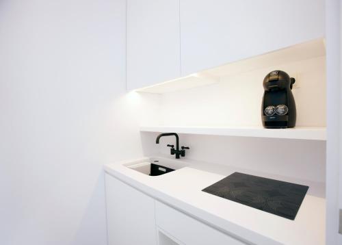 a kitchen with white cabinets and a sink at Quinta Do Miguel in Aldeia do Meco