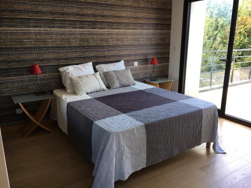 une chambre avec un grand lit et une grande fenêtre dans l'établissement Bassin d 'Arcachon House with heated pool, à La Teste-de-Buch