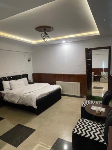 a bedroom with a bed and a table and a mirror at Mussiaree Hotel in Murree