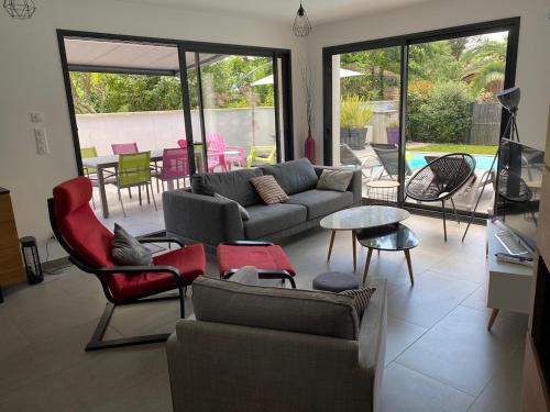 un salon avec un canapé, des chaises et une table dans l'établissement Bassin d 'Arcachon House with heated pool, à La Teste-de-Buch