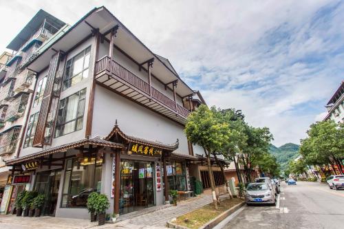 a building on a street with a car parked in front at Zhangjiajie Warm Wind Inn in Zhangjiajie